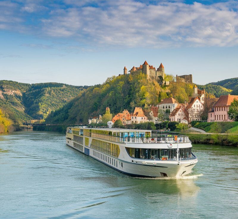 River cruise ship sailing a calm European river at golden hour